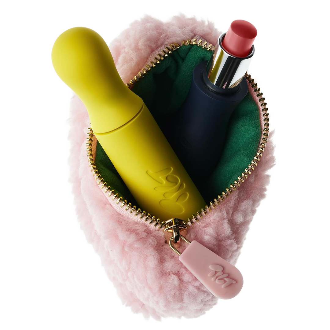 A pink pouch containing a yellow object and a lipstick.