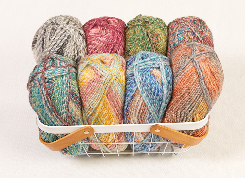 A basket filled with colorful yarn skeins.