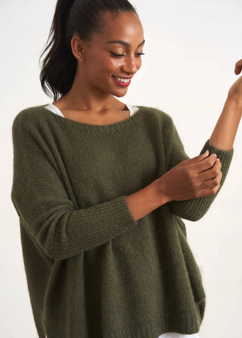 A model wearing a dark, khaki green knitted sweater