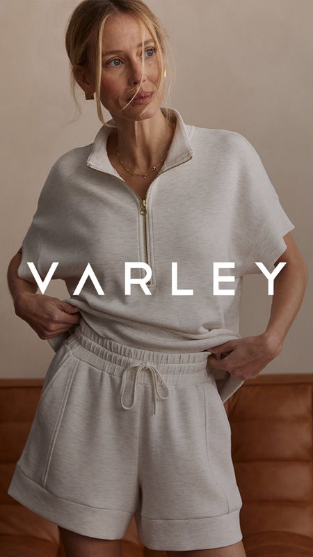 Model wearing a light gray outfit with Varley branding.