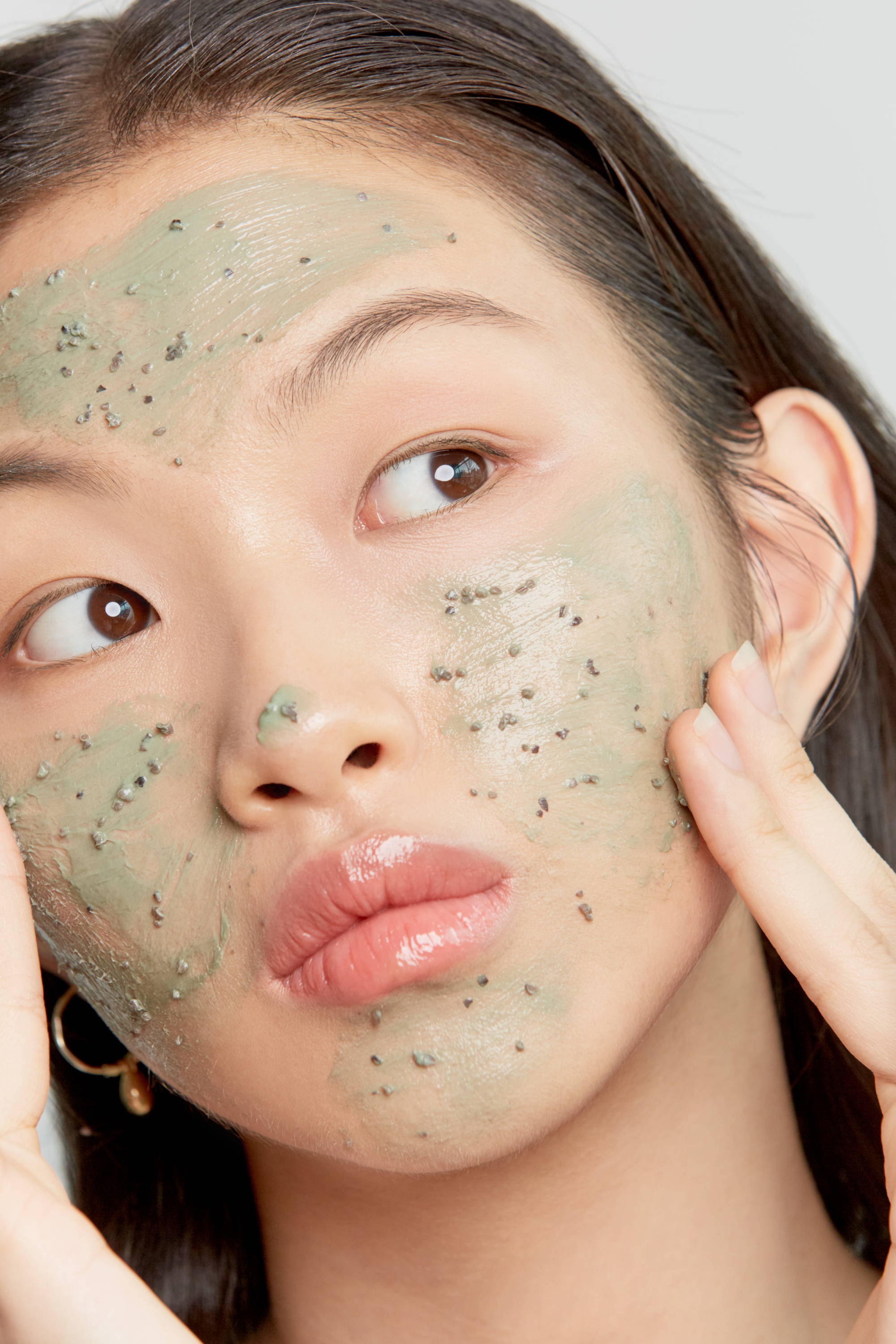 Asian girl using the mugwort pore clarifying wash off pack on her face