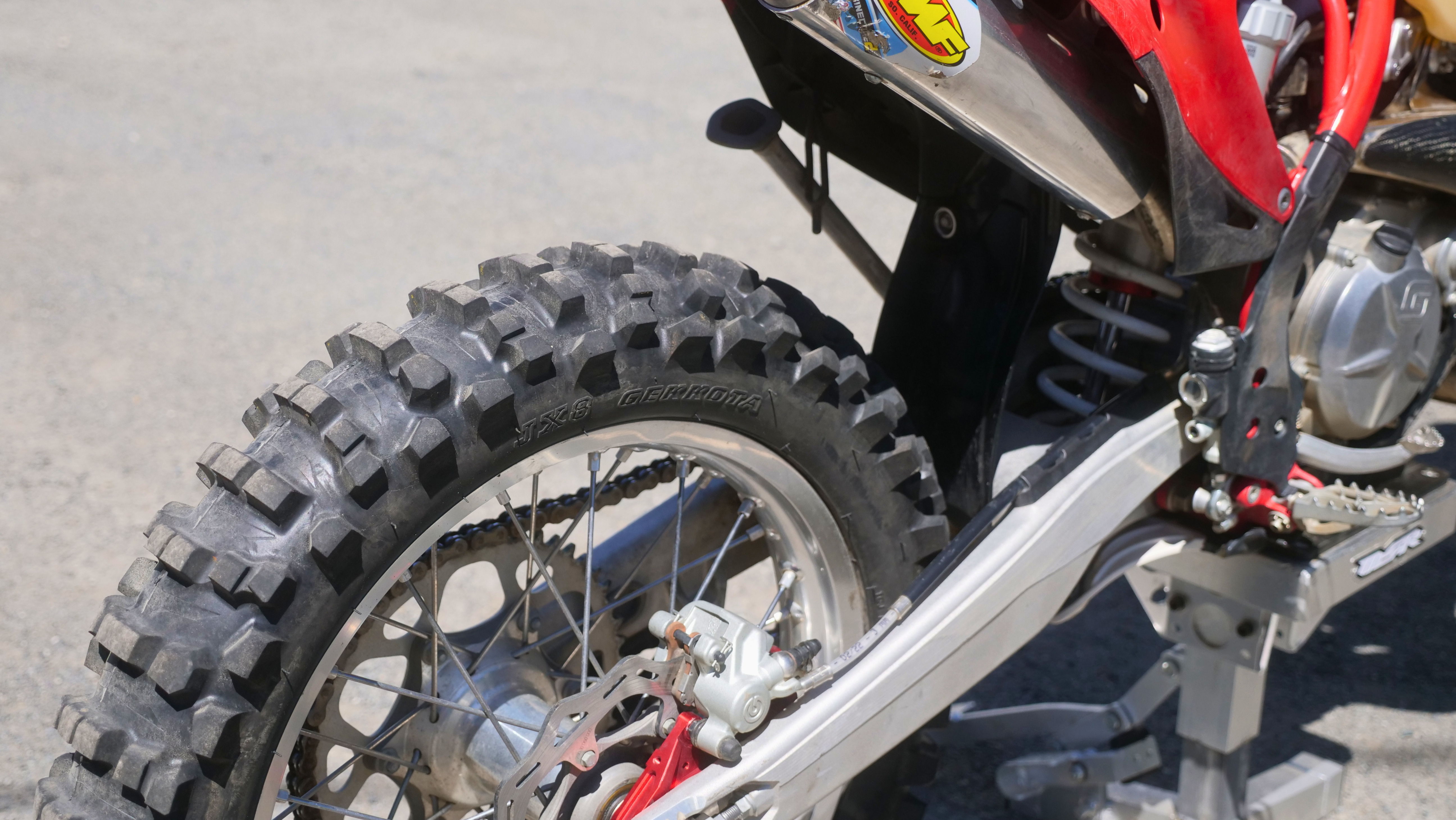Close-up of a motorcycle tire and rear suspension.