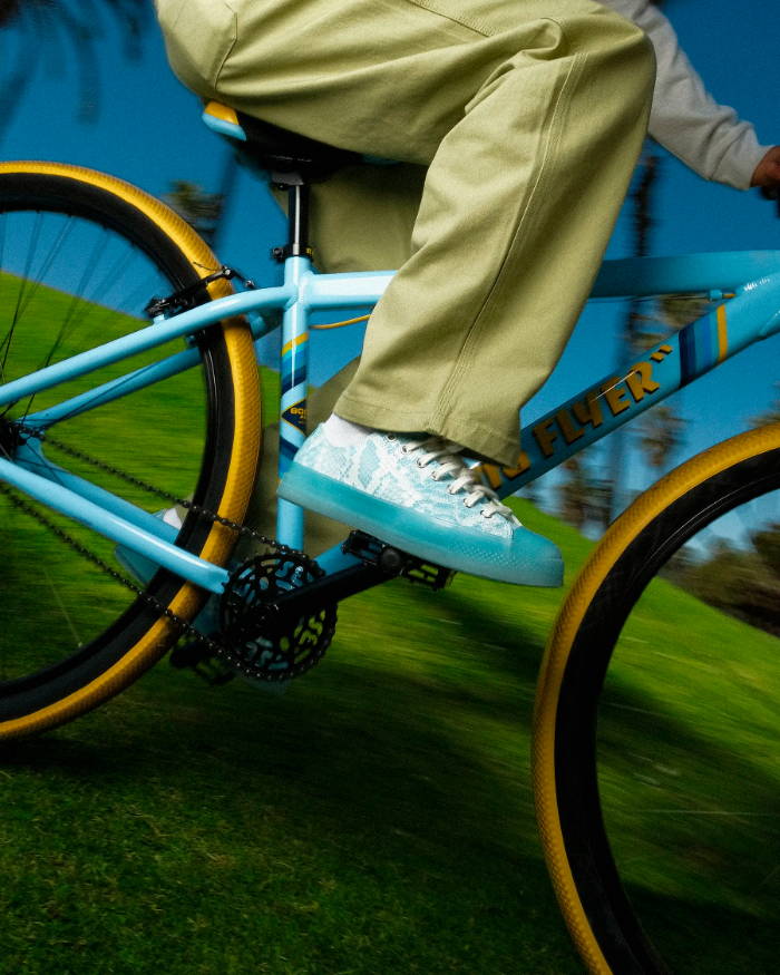 man riding bike in blue converse x golf wang chucks