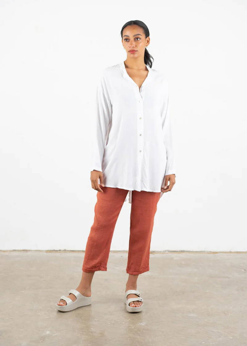 A model wearing a white oversized long sleeved shirt