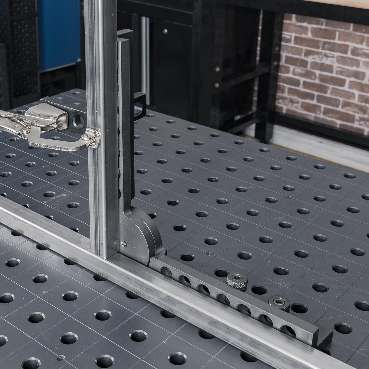 A close-up of a work surface with holes and metal fixtures.