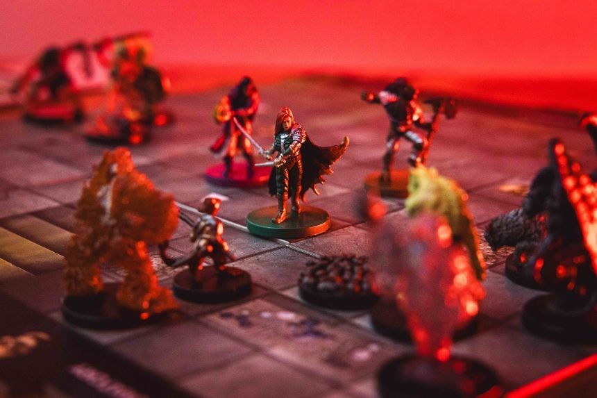 Miniature figurines on a game board with a red background.