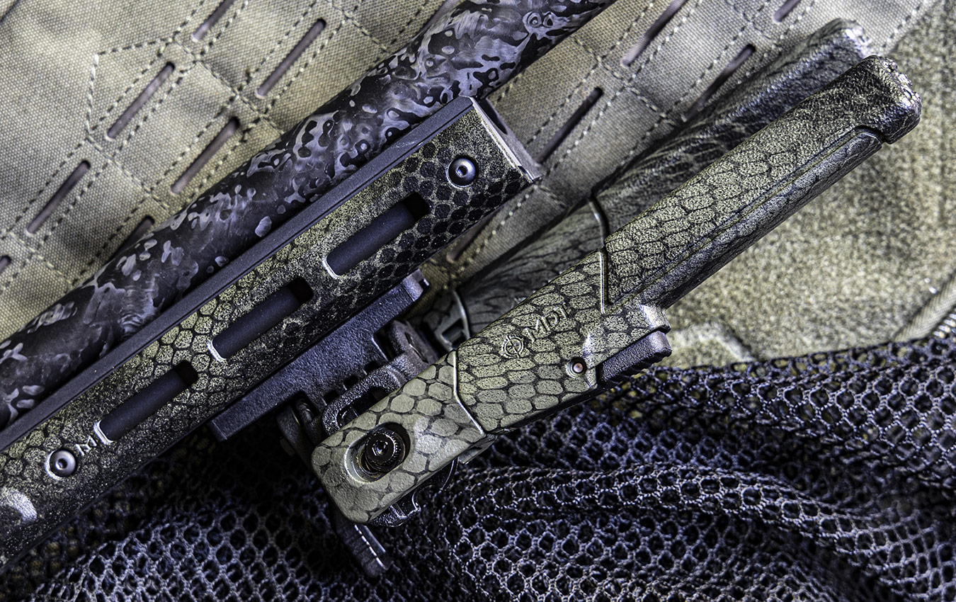 A close-up of a firearm on tactical fabric.