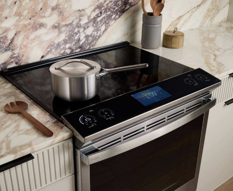 Modern kitchen stove with a pot and digital display.