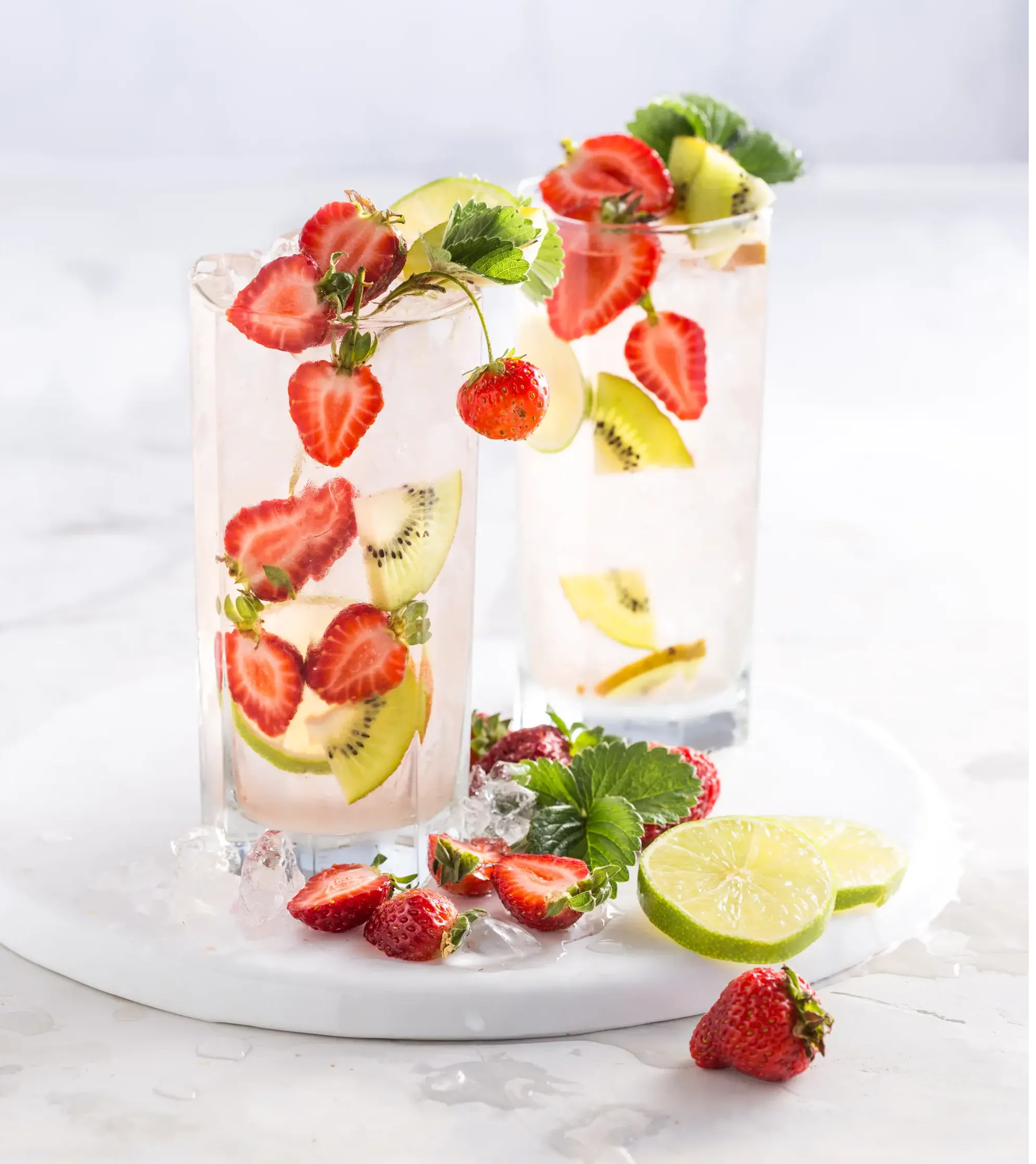 Iced water with sliced strawberries and kiwi inside