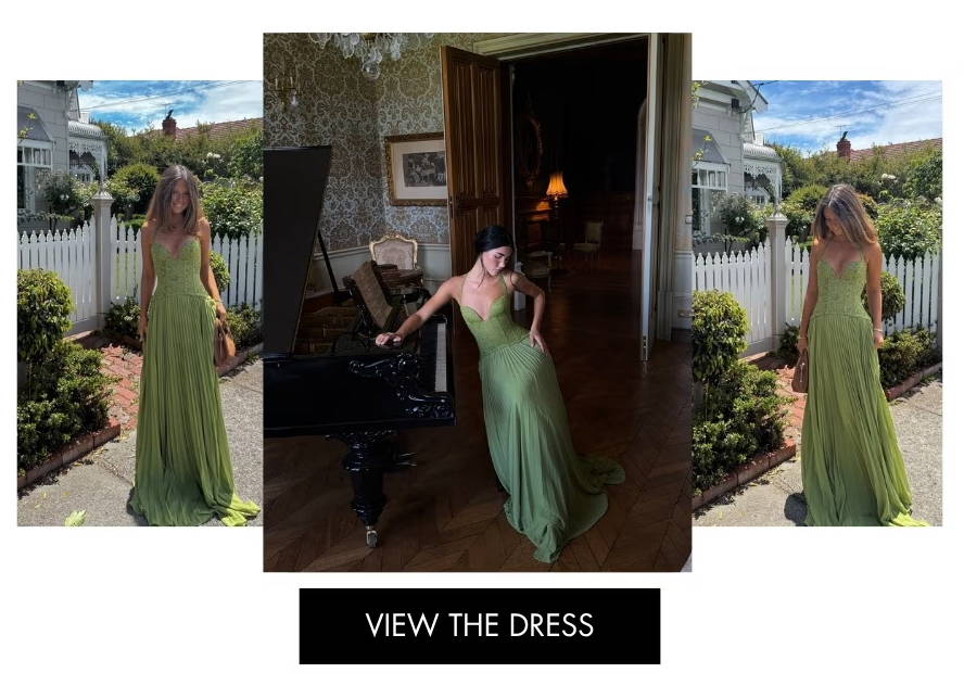 Woman in a green dress, posing outdoors with a scenic background.