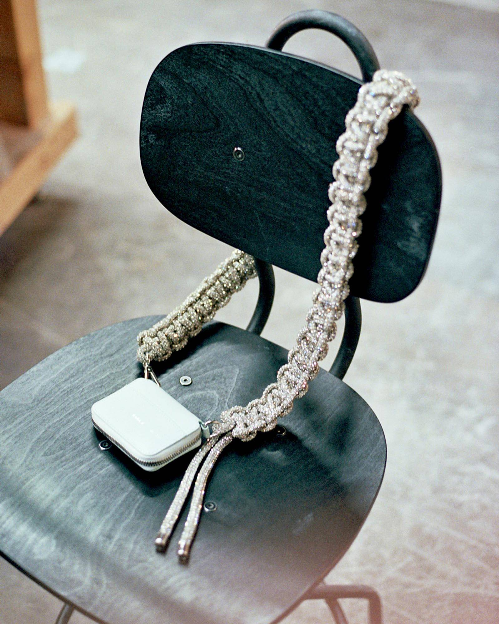 A sparkly bike wallet by Kara on a black wooden chair. 