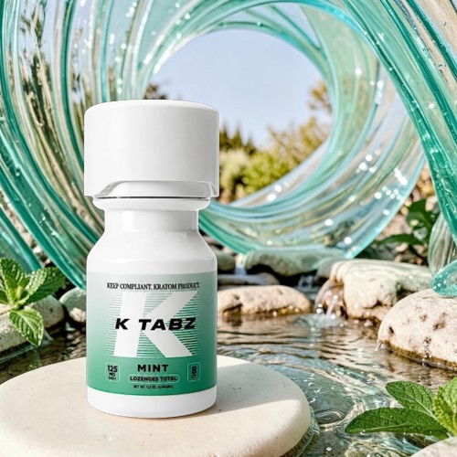 Bottle of K TABZ dietary supplement surrounded by rocks and water.
