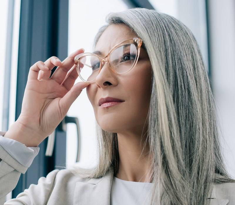Woman with grey hair wearing light frames