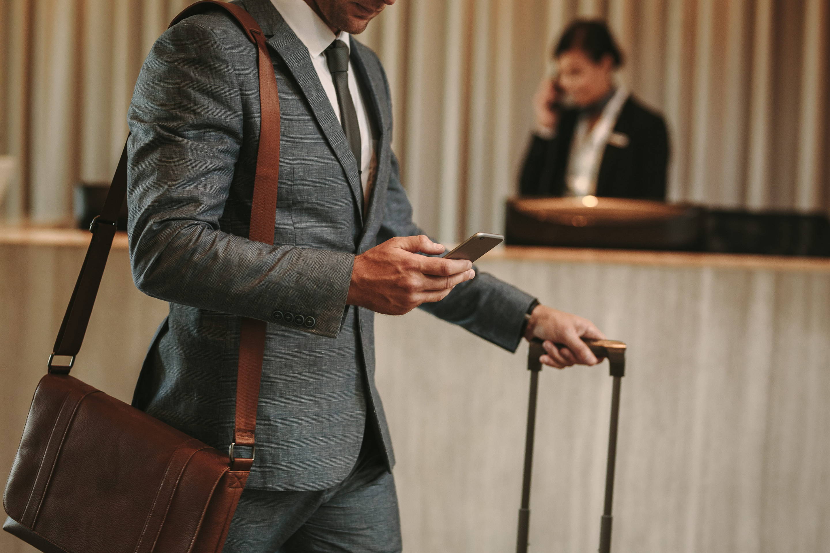 Man in grey plaid suit checks in to luxury hotel 