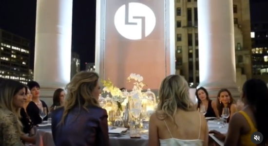 Dinner gathering at night with people seated around a beautifully decorated table.