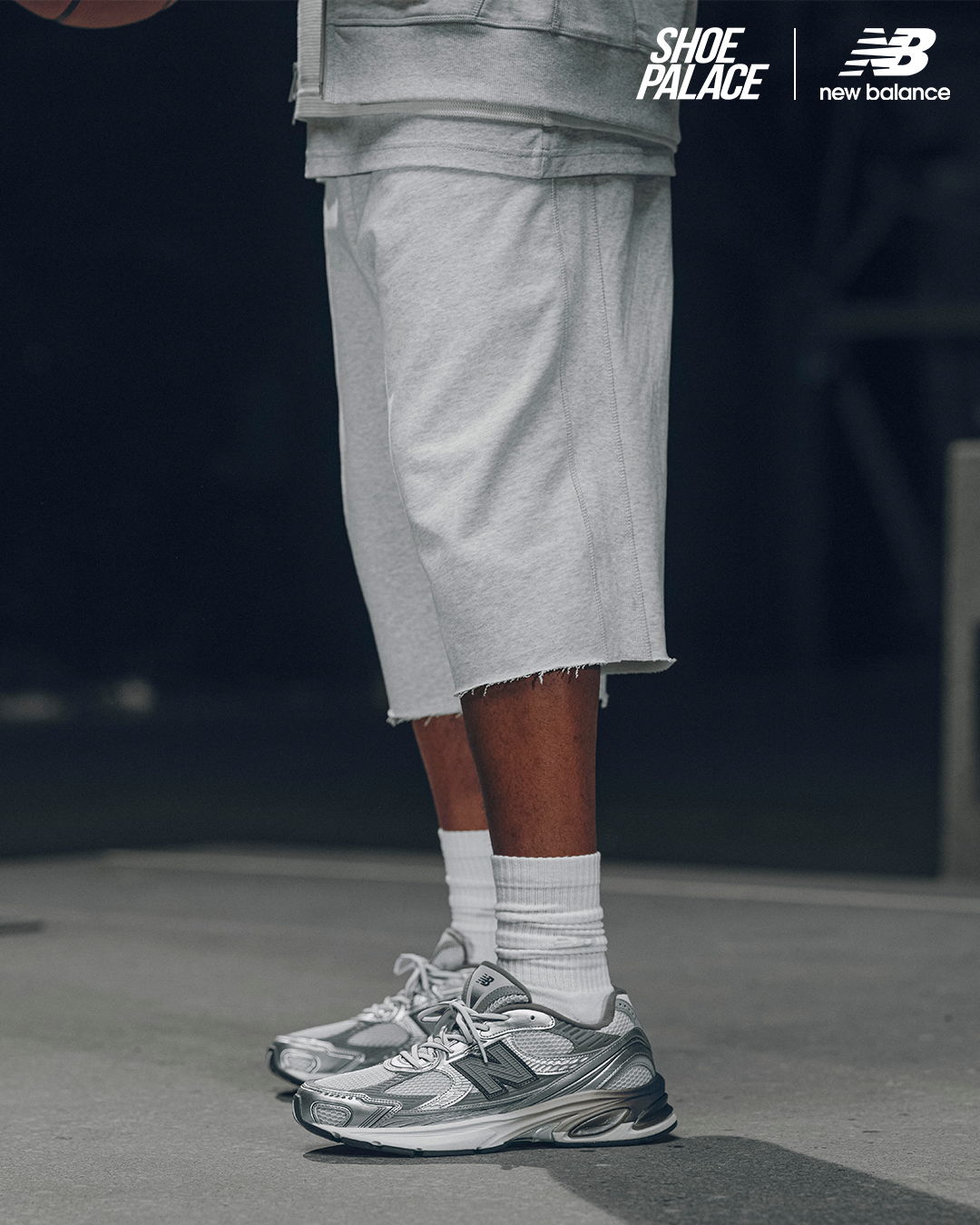 Person wearing gray shorts and silver sneakers, standing on a surface.