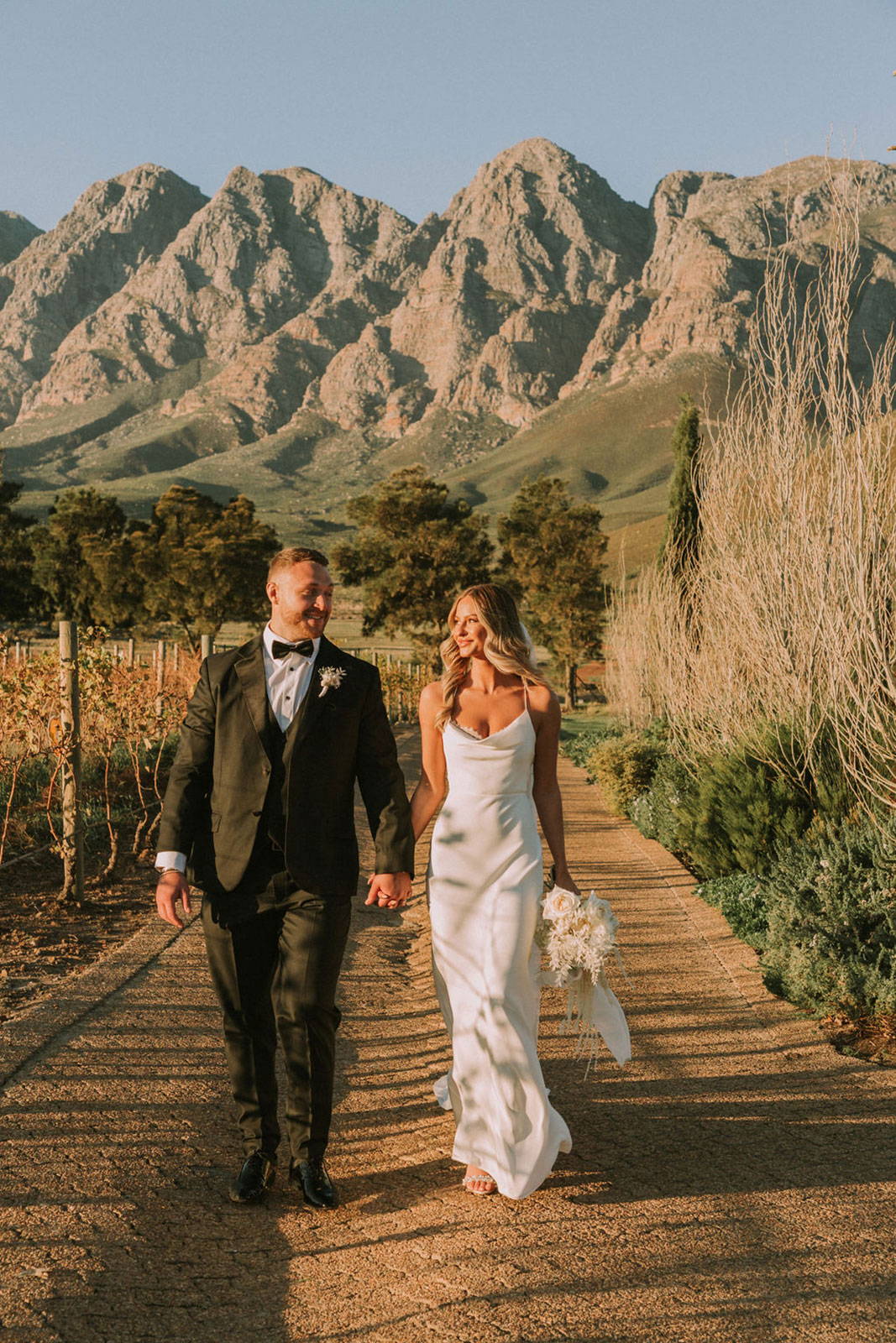 Bride and Groom walking with mountains behind