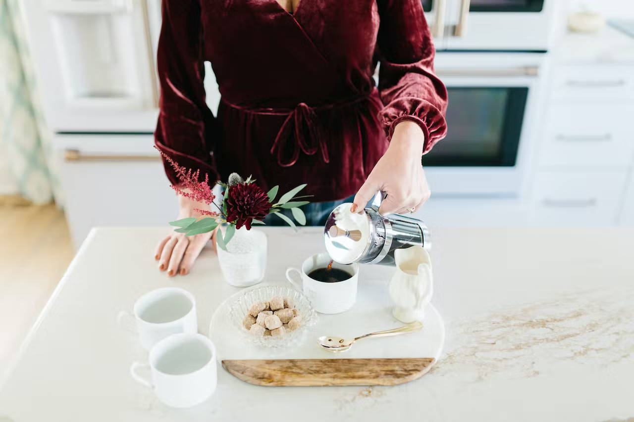 Making coffee in matte white kitchen