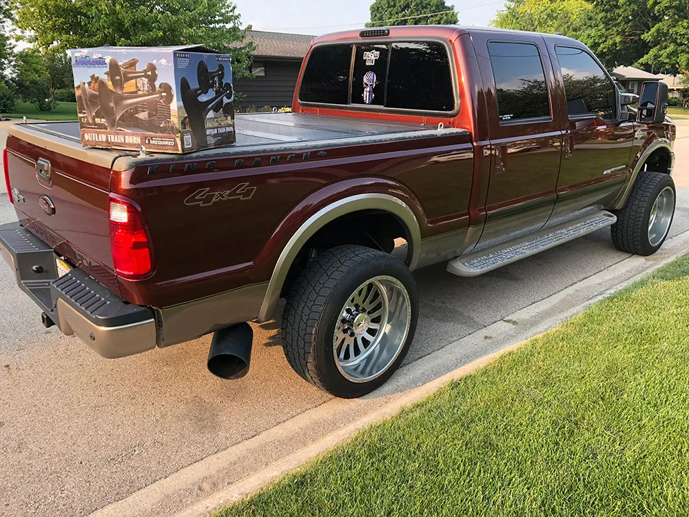 Maroon and tan 2006 Ford F250 King Ranch Super Duty with HornBlasters Outlaw train horn box on the bed