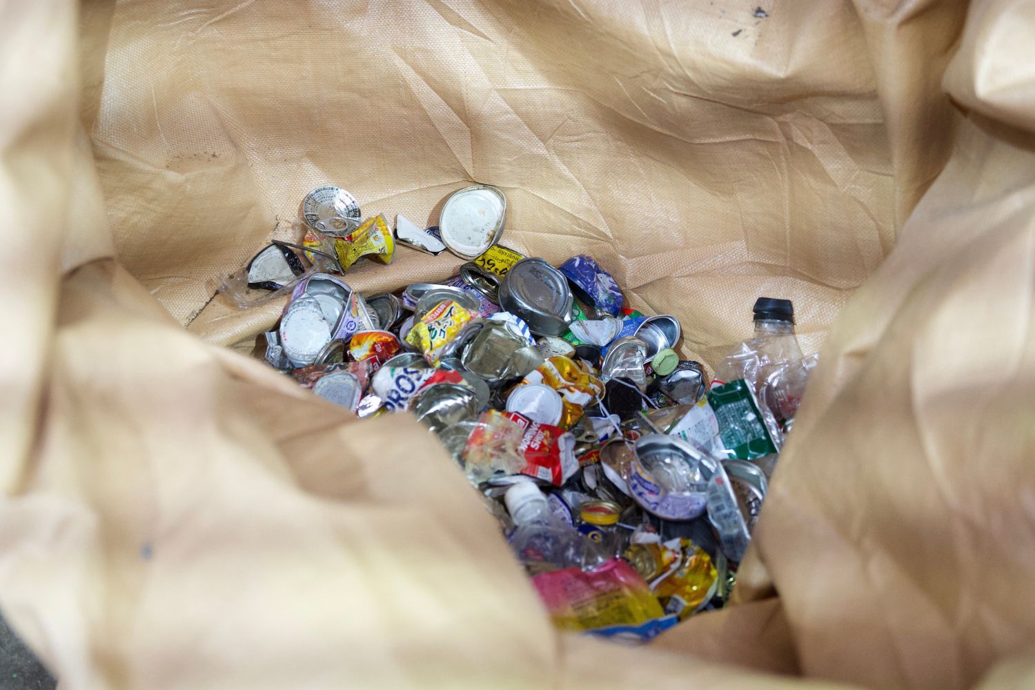 A pile of assorted metal caps and bottle tops in a bag.