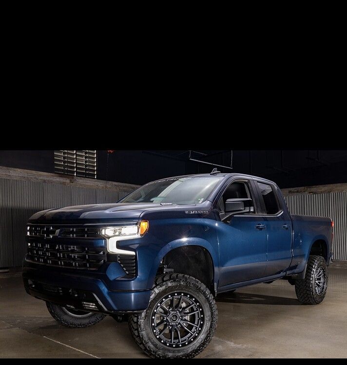 Studio front-three-quarter view Brian's dark blue lifted 2022 Chevy Silverado with Nitto Trail Grappler off-road tires HornBlasters Stealth Spare Tire Delete featured customer install gallery photo 1