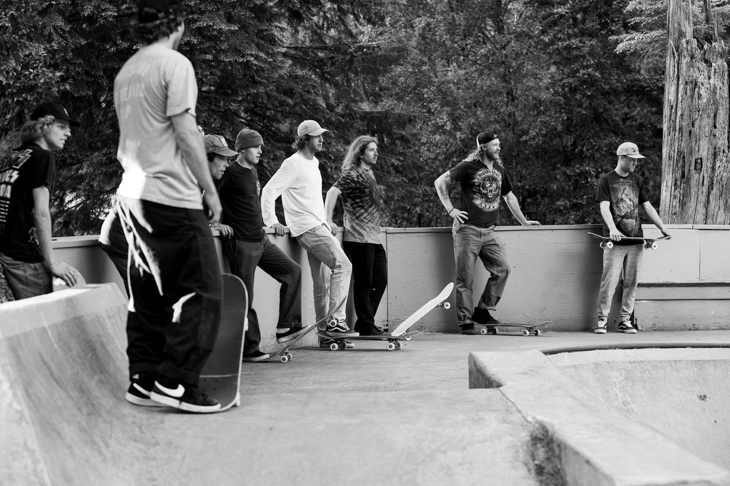 Group of people watching skateboarding at a skatepark, black and white photo.