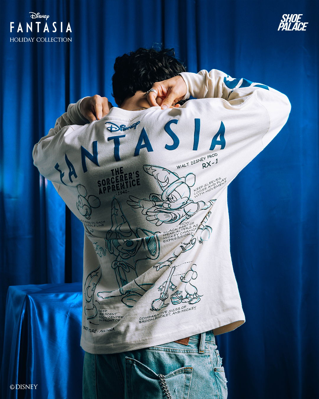 Person wearing a Fantasia sweatshirt with a blue background.