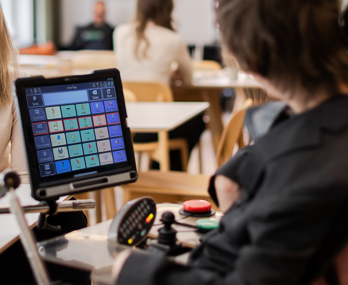 Man with cerebral palsy using scanning access on an assistive communication device