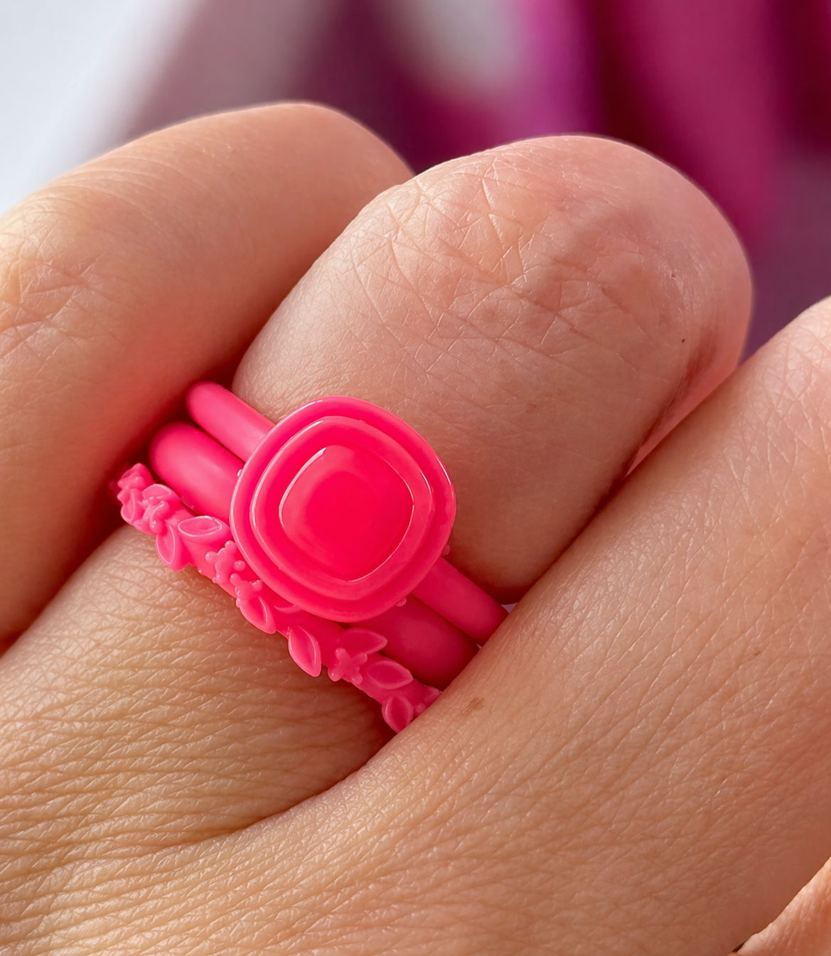 High profile stackable engagement ring with cushion stone and floral wedding band stacked on finger, showing setting height