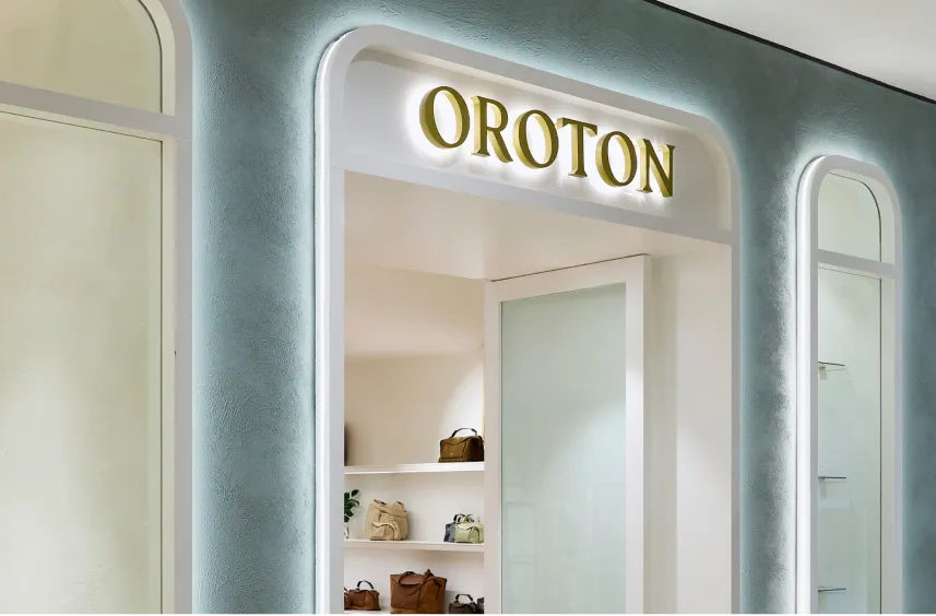 Oroton store entrance with a light blue wall and display shelves.