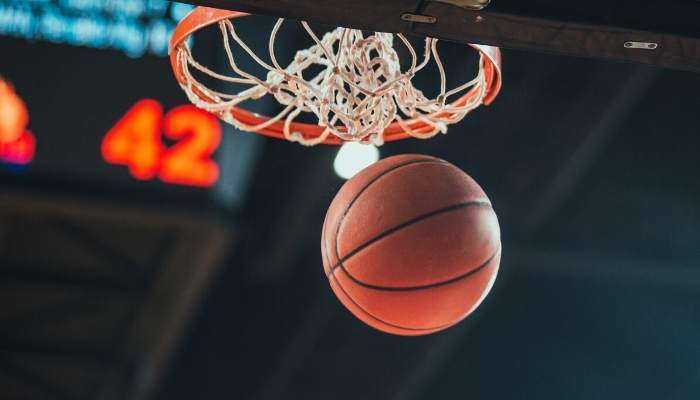 Basketball going through hoop at indoor stadium