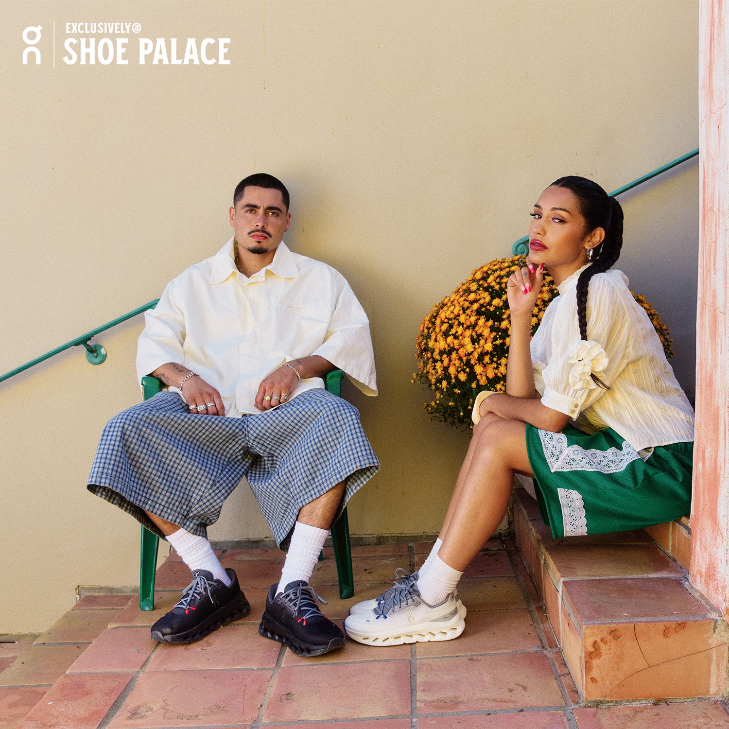 Man and woman sitting on stairs, wearing casual clothing.