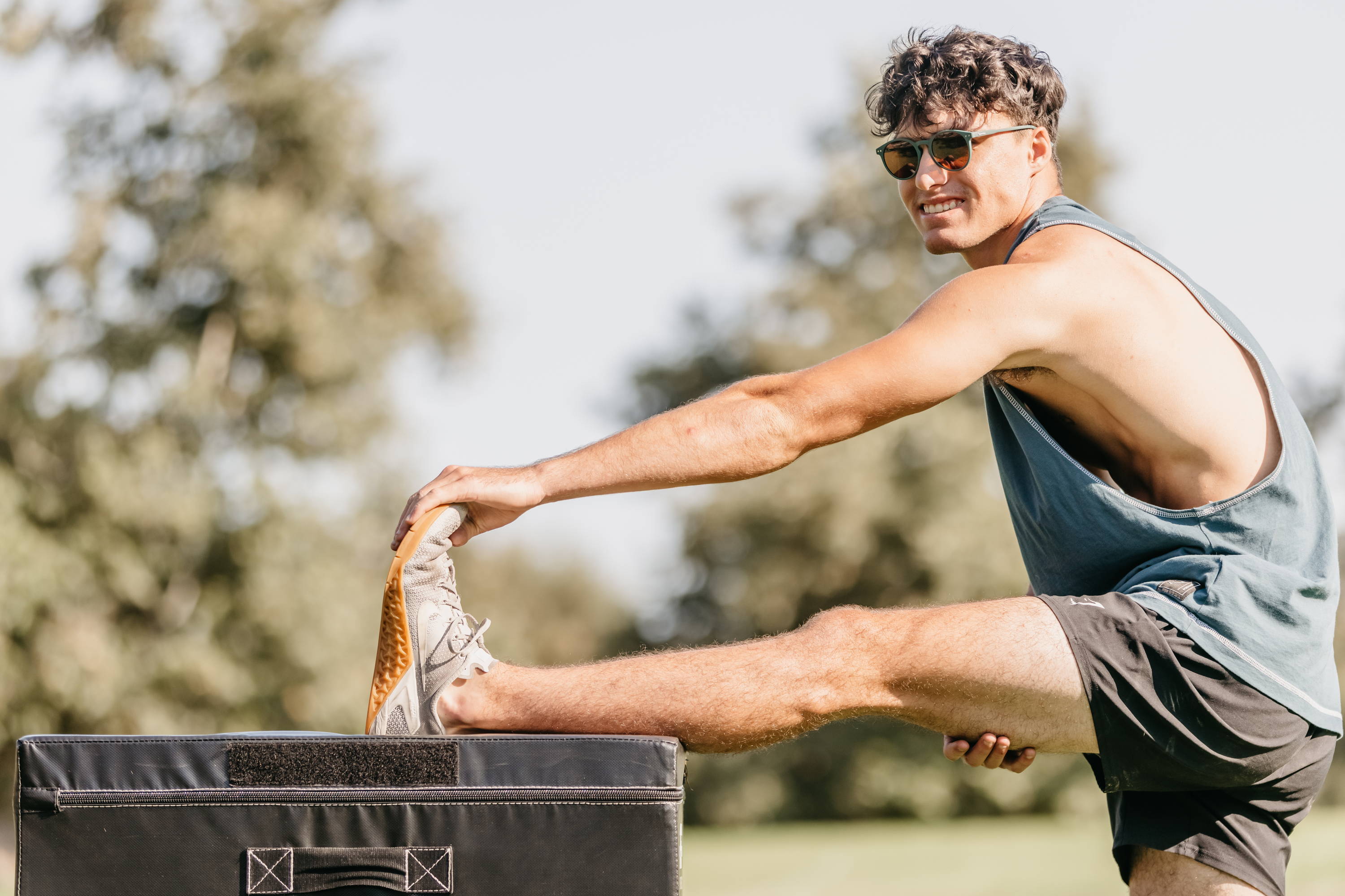 Runner stretching and wearing sunglasses