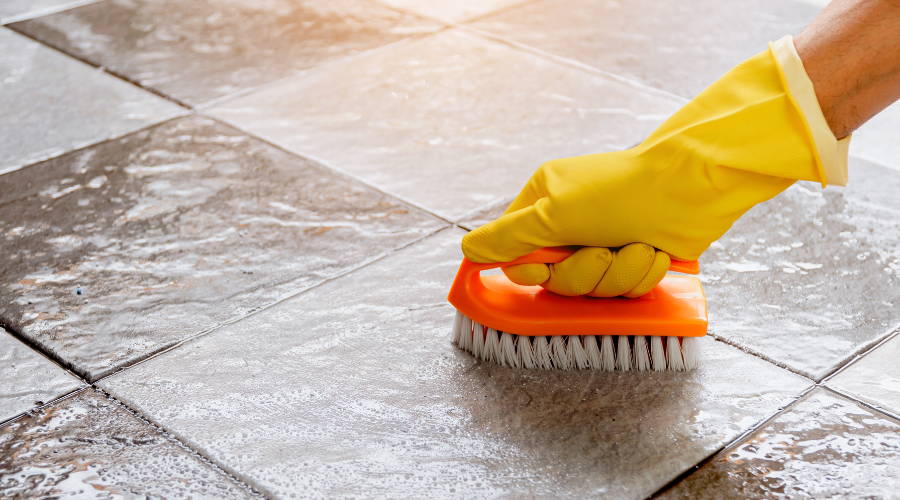 scrubbing tiles with a brush
