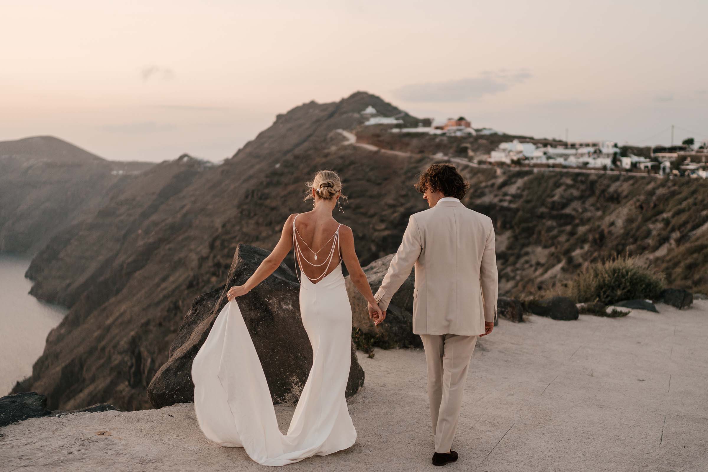 Tad and Alexa standing on mountain-side at their Santorini wedding