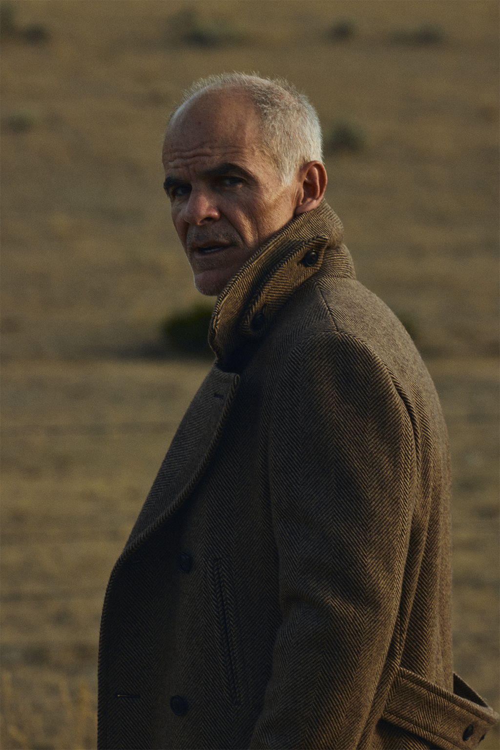 Michael Kelly wearing the Barrow Wool Herringbone Double Breasted Topcoat on a dirt road in Paradise Valley, Montana.