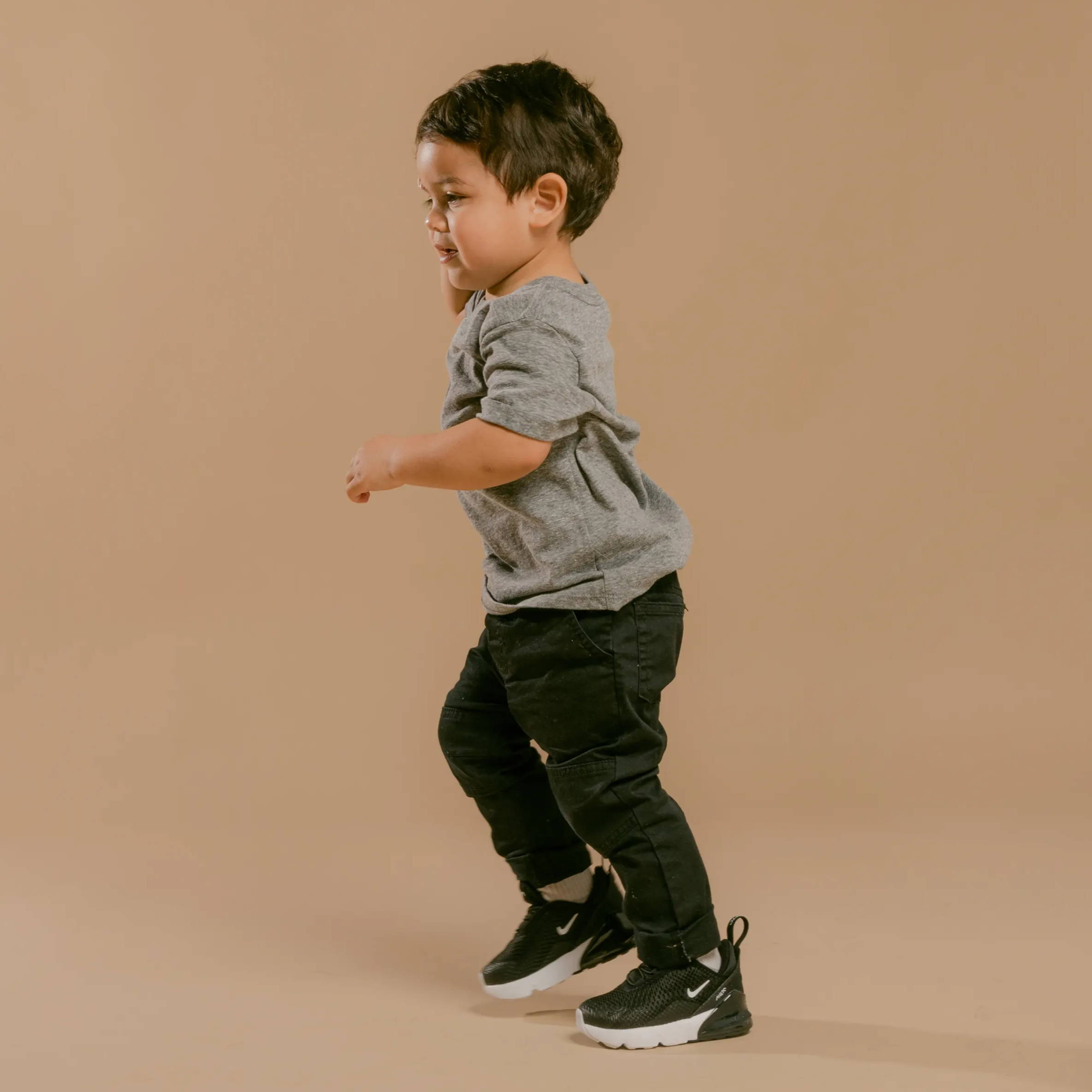 young boy wearing black nike shoes