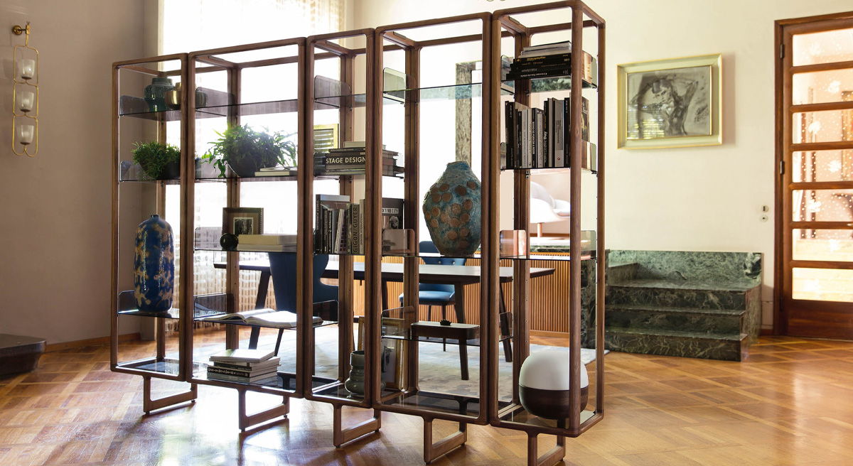 Modern Porada wooden bookshelf with decorative plants and books in a cozy room.