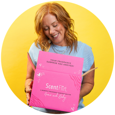 Woman smiling while opening a pink ScentFlirt box