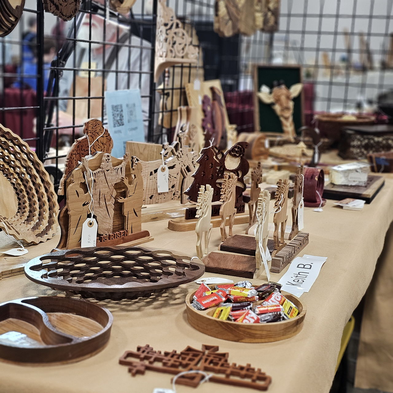 Wooden crafts and decorations displayed on a table at a market.