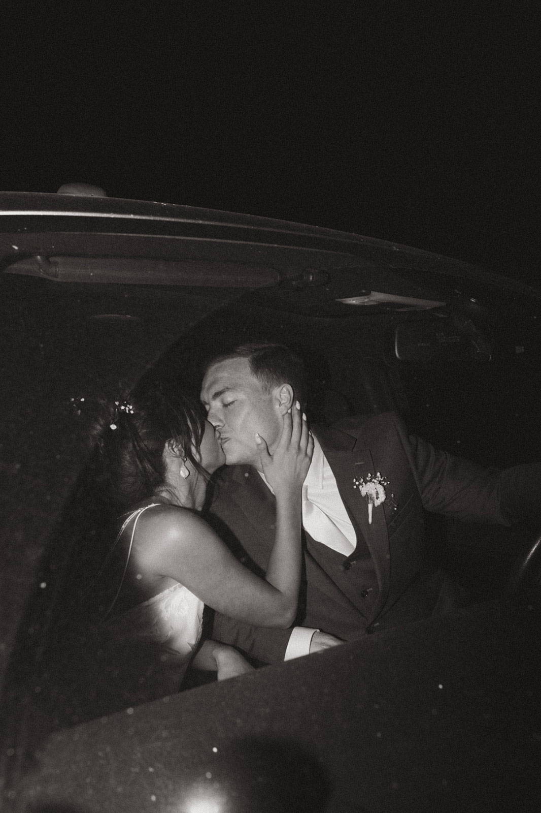 Groom and Bride sharing a kiss in the car