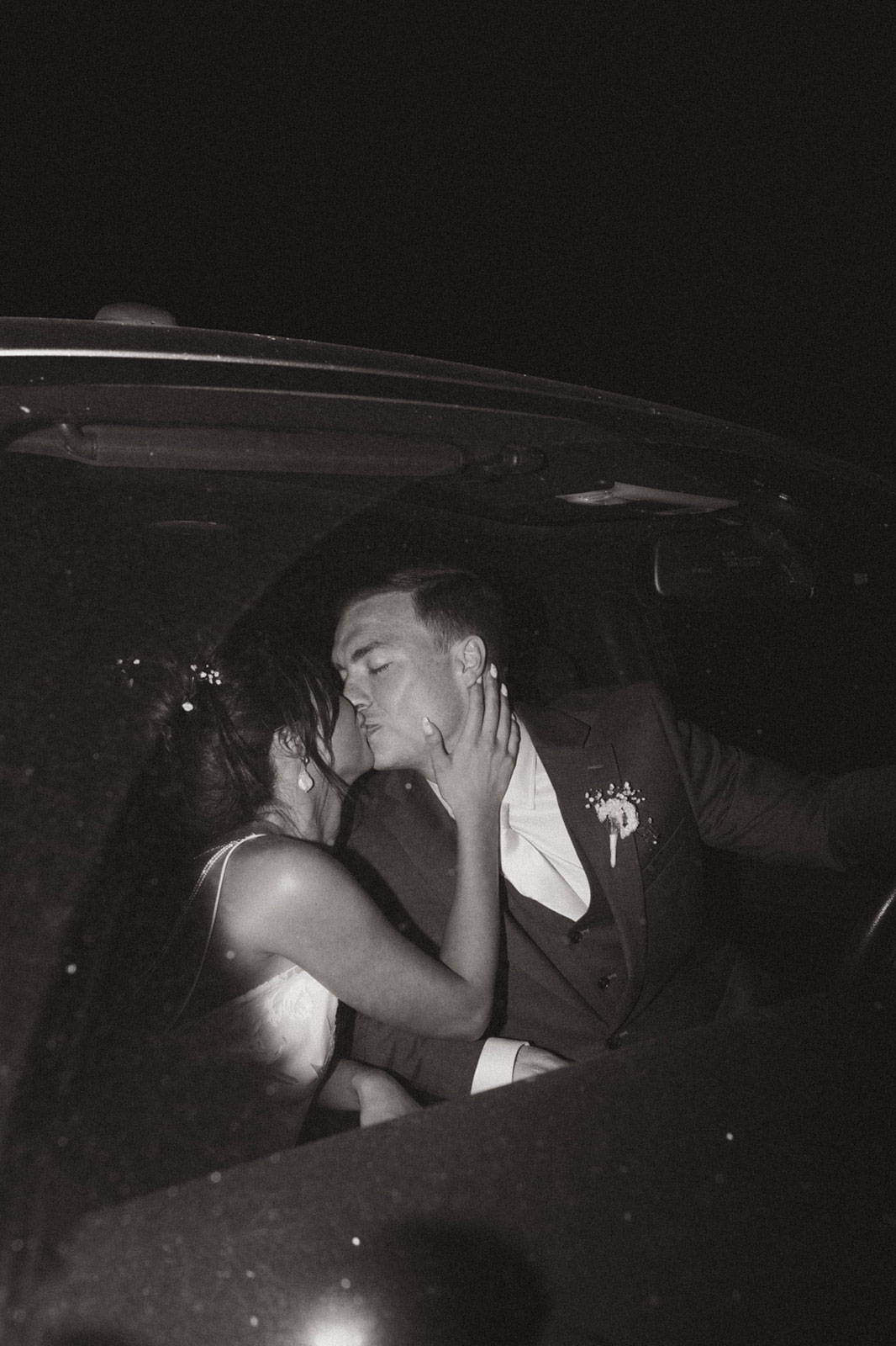 El novio y la novia compartiendo un beso en el coche