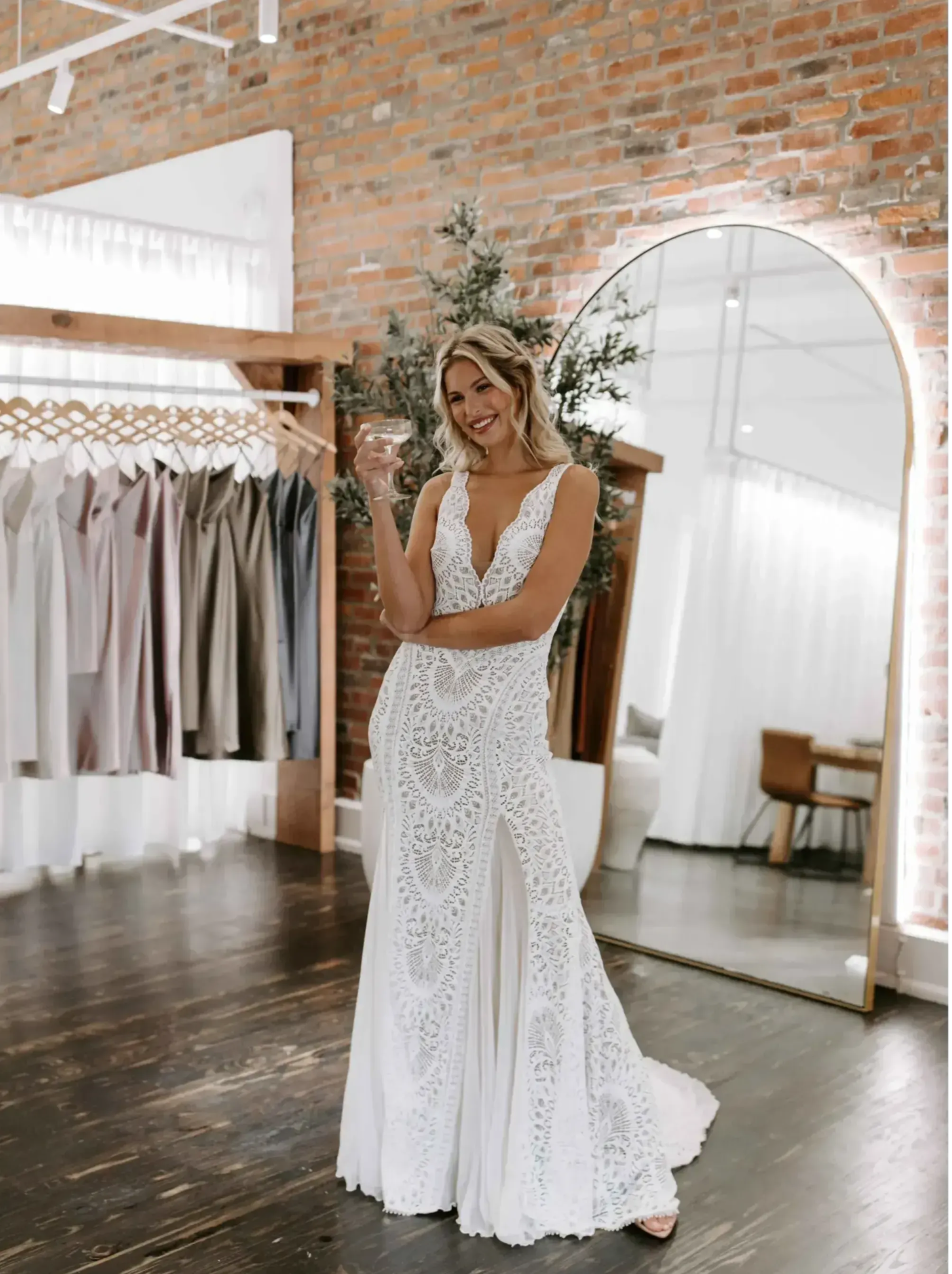 Bride holding champagne in GRACE wedding gown