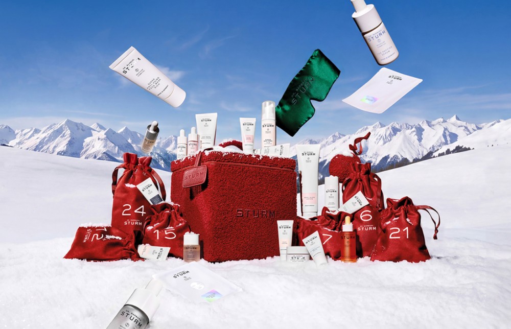 Red gift boxes and skincare products in a snowy mountain landscape.