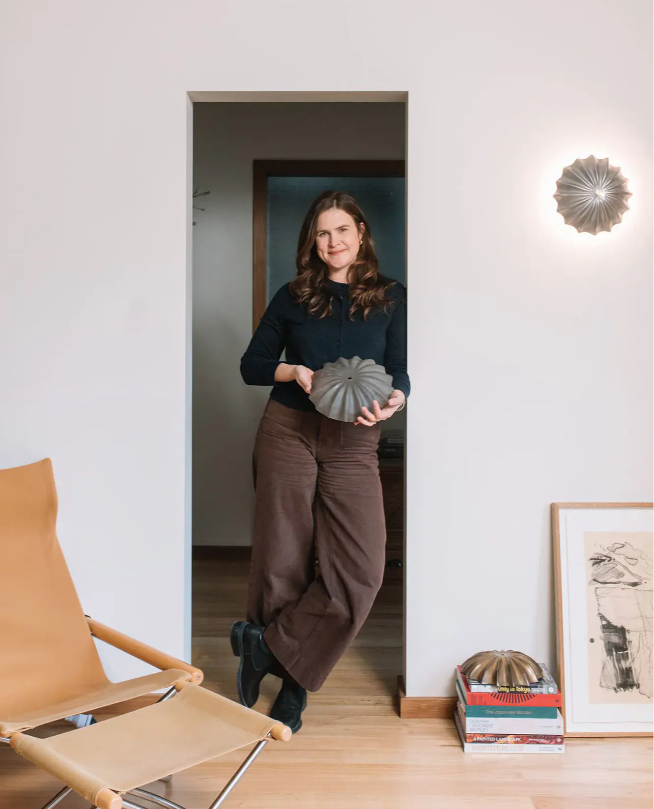 Milly Dent holding one of her Hexacorallia wall sconces.