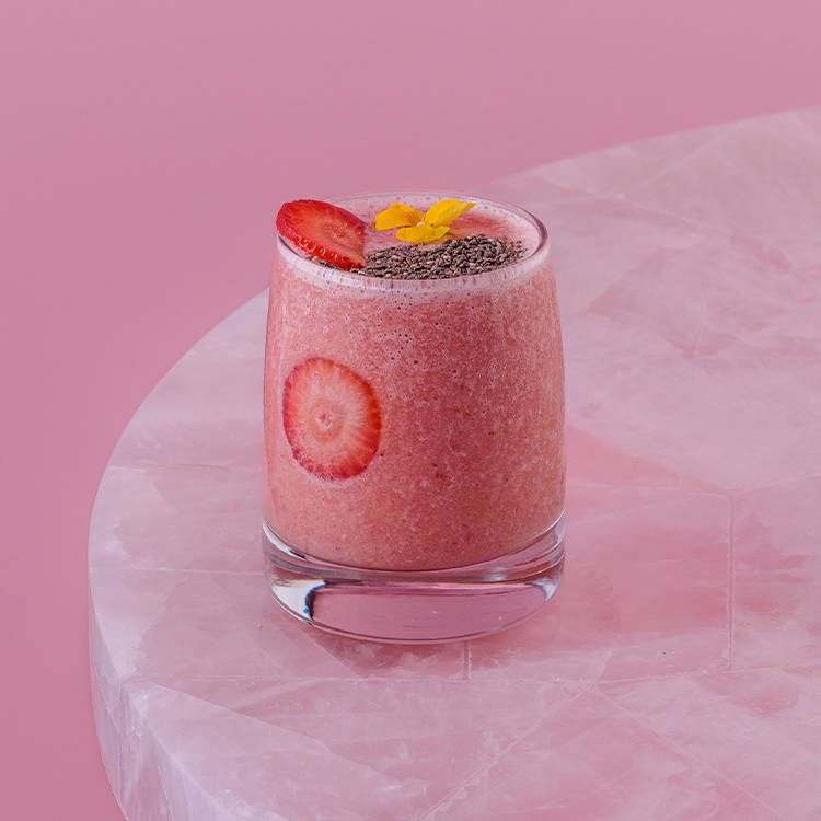 Strawberry & banana smoothie with chia seeds on pink background