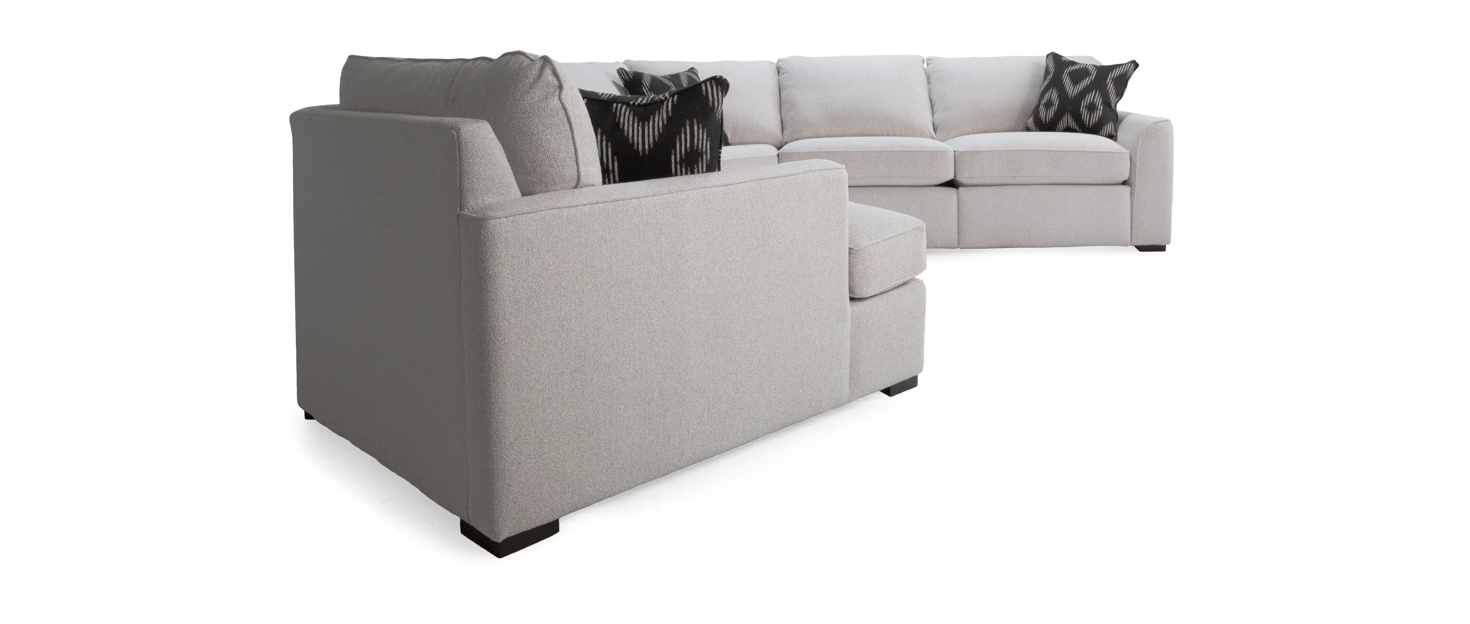 A modern light gray sectional sofa with decorative pillows.