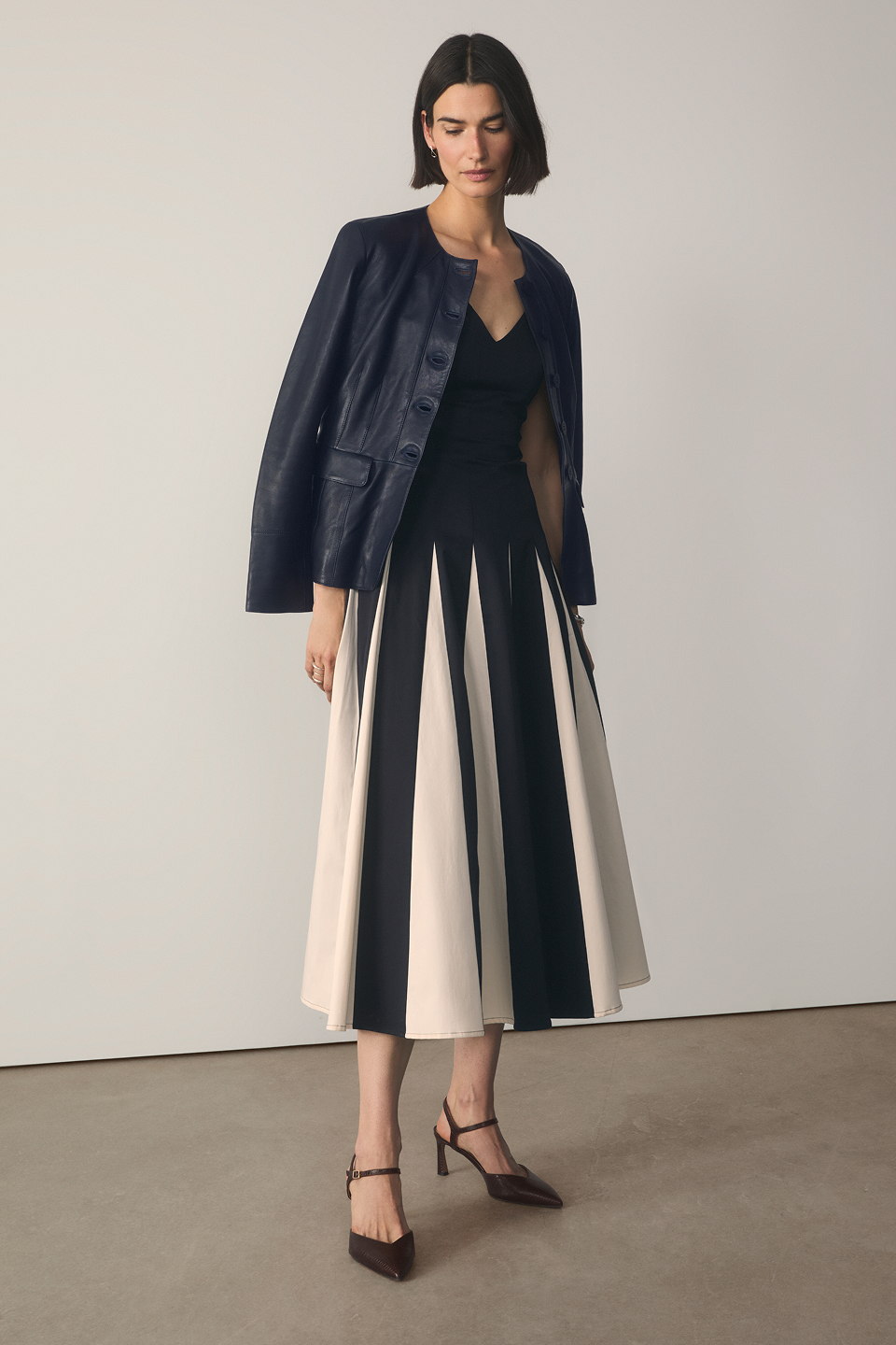 Model wearing navy and stone Salina dress with navy Ginevra leather jacket