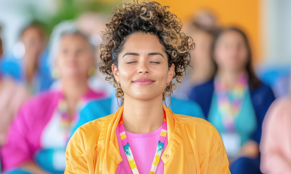 Woman smiling with closed eyes, surrounded by a group of people.