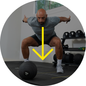 Man exercising with a medicine ball in a gym setting.